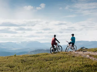 Stisykling på Golsfjellet Visit Gol Paul A Lockhart, to personer som sitter på syklene sine og ser utover fjellet.