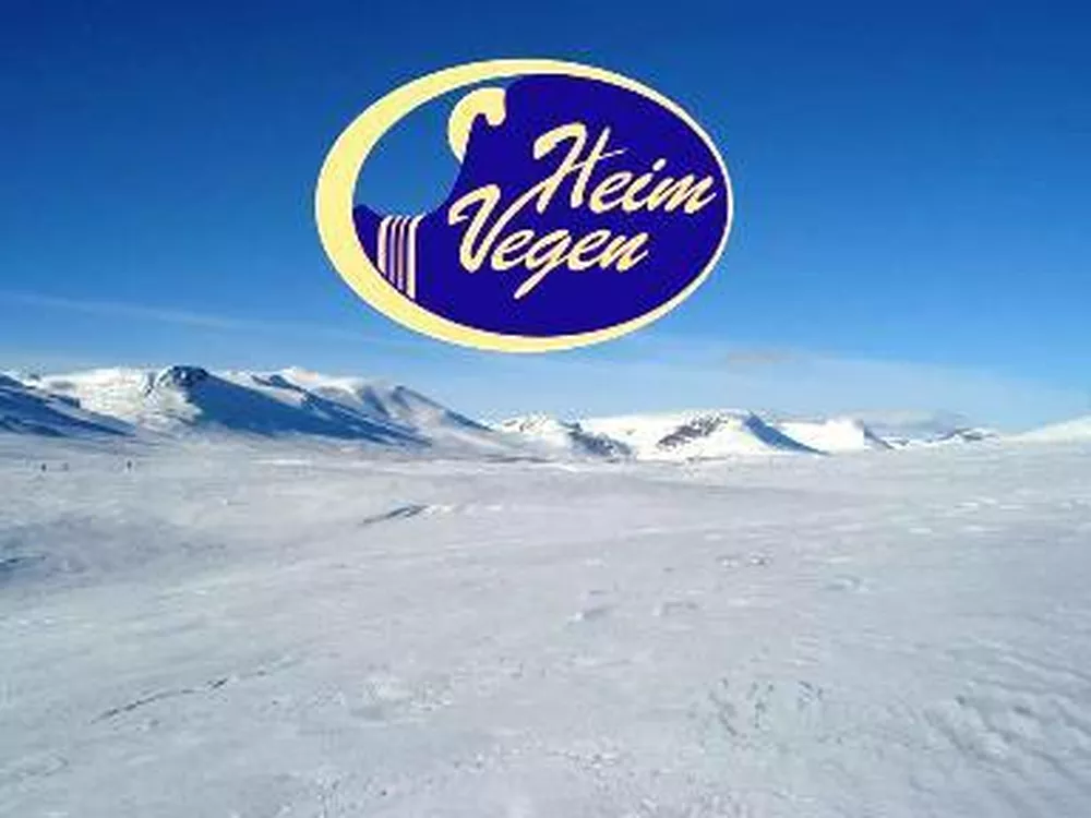 Heimvegen logo, i blå, gul, hvitt og lilla, i bakgrunnen er det snødekkede fjell i solskinnsvær.