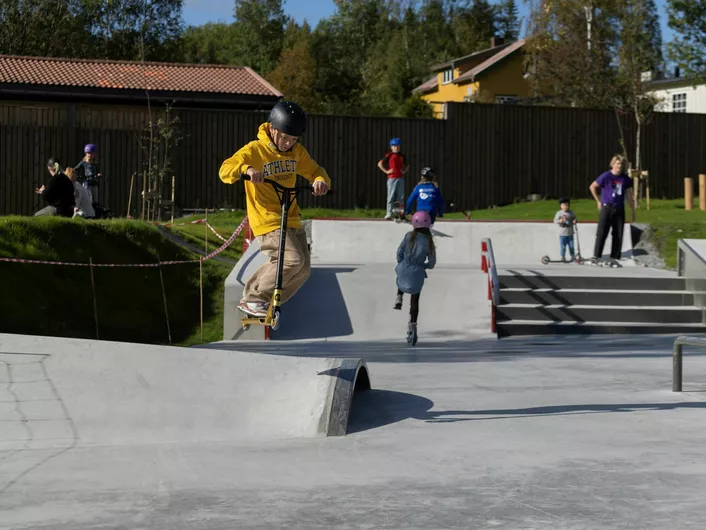 Gutter og jenter som bruker parken, til å skate eller sparkesykle.