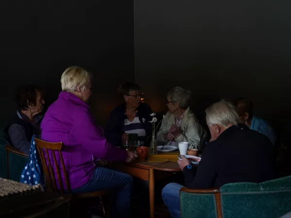 En gjeng som hygger seg rundt et bord på flattbrødbakeriet.