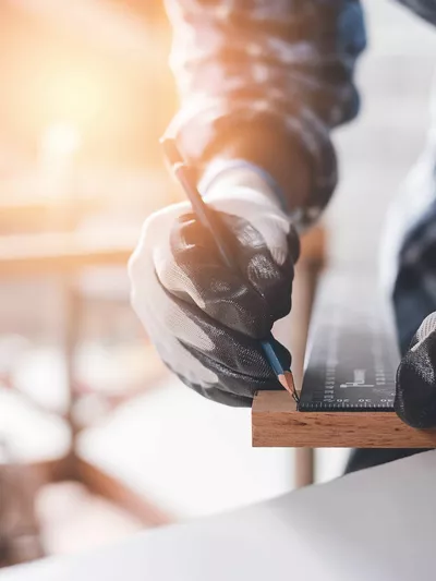 Mann som til ulike mål på en planke med tre