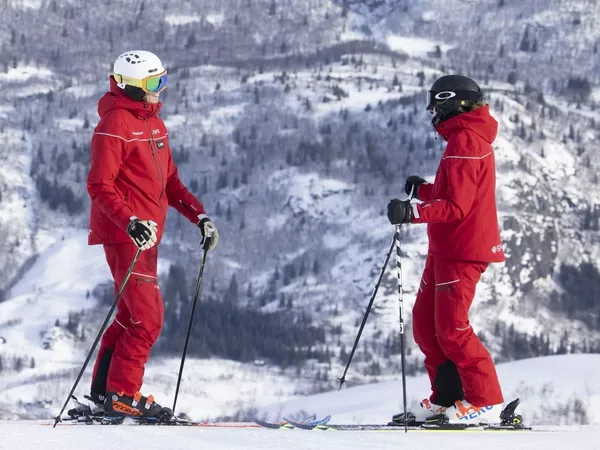 To ski-instruktører av skistar i bakken.