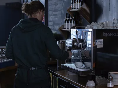 Mann som lager kaffe på kafeen i solheisen Hemsedal