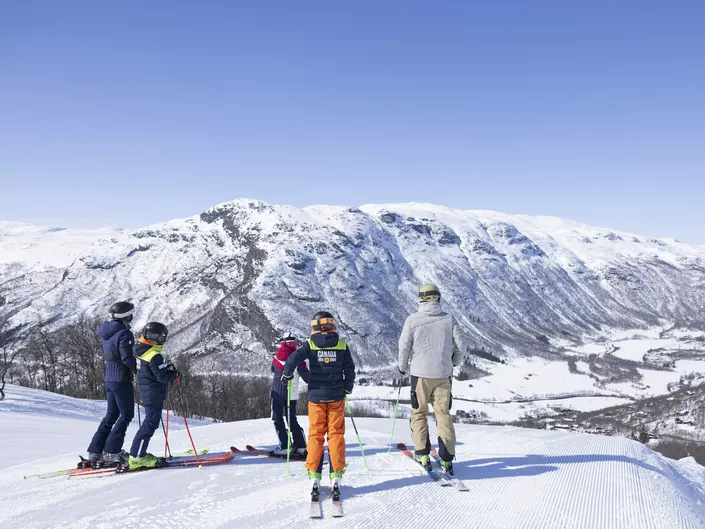 Familie som er på ski i solheisen i Hemsedal