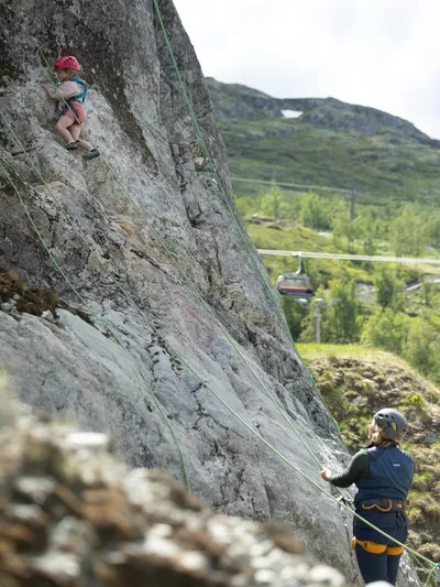 Dame som passer på en jente som klatrer i fjellet i Hemsedal