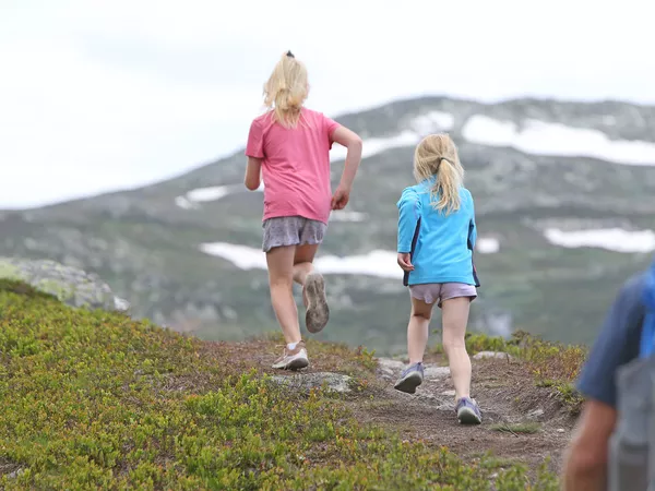 Små jenter som løper i fjellet.