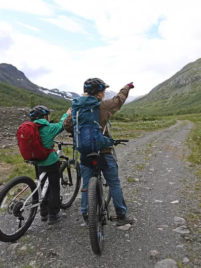 To mennesker som peker opp på fjellet foran dem