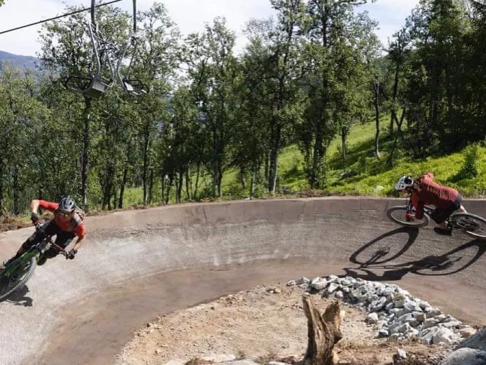 To mennesker som kjører i en skarp sving i Hemsedal skisenter