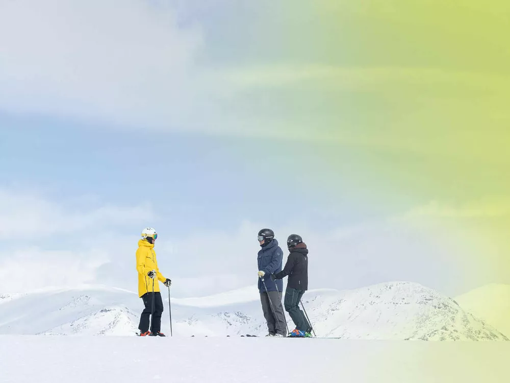 Alpinister på fjellet med gult lys i hjørnet