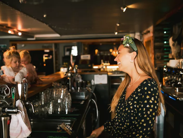 Smilende dame bak disken.