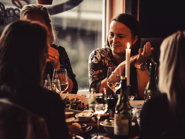 Damer som nyter vin og skalldyr.