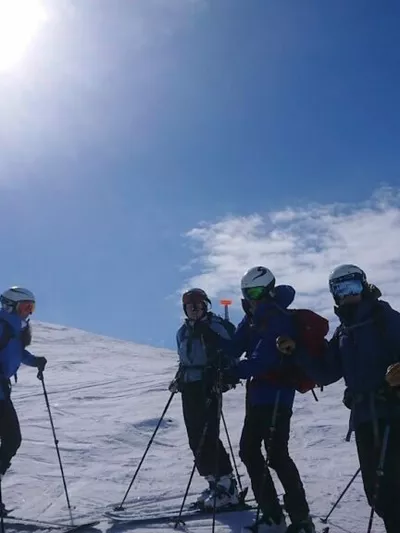 En gjeng med mennesker som er kommet på toppen og er klare til å kjøre nedover (vinter)