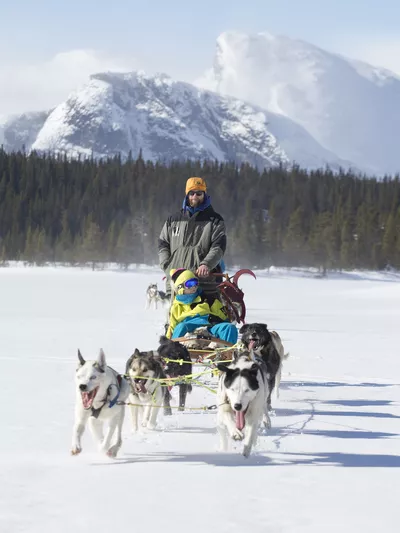 Mann og barn som kjører hundekjøring om vinteren i Hemsedal